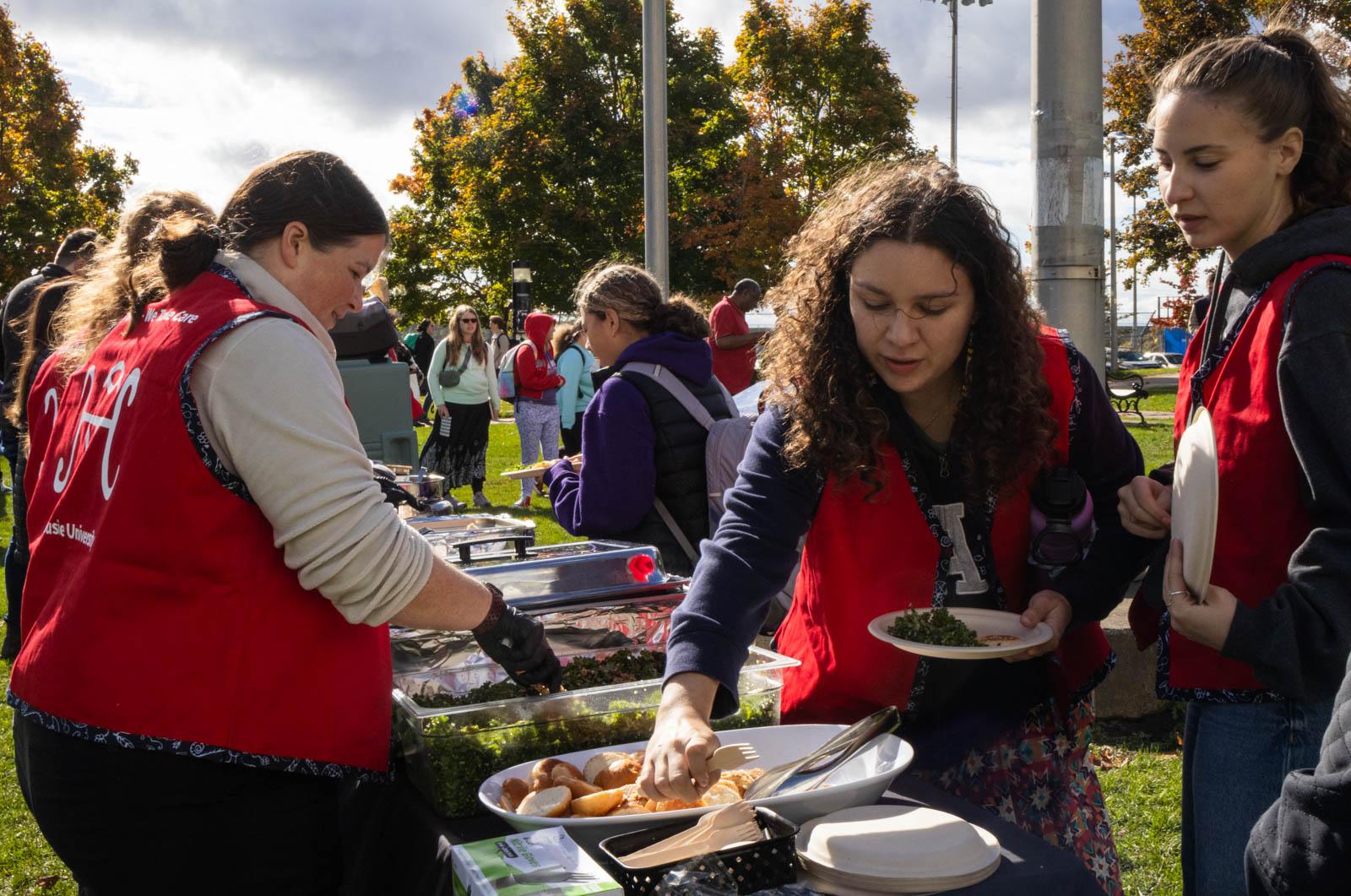 A group of women at a food buffet

Description automatically generated