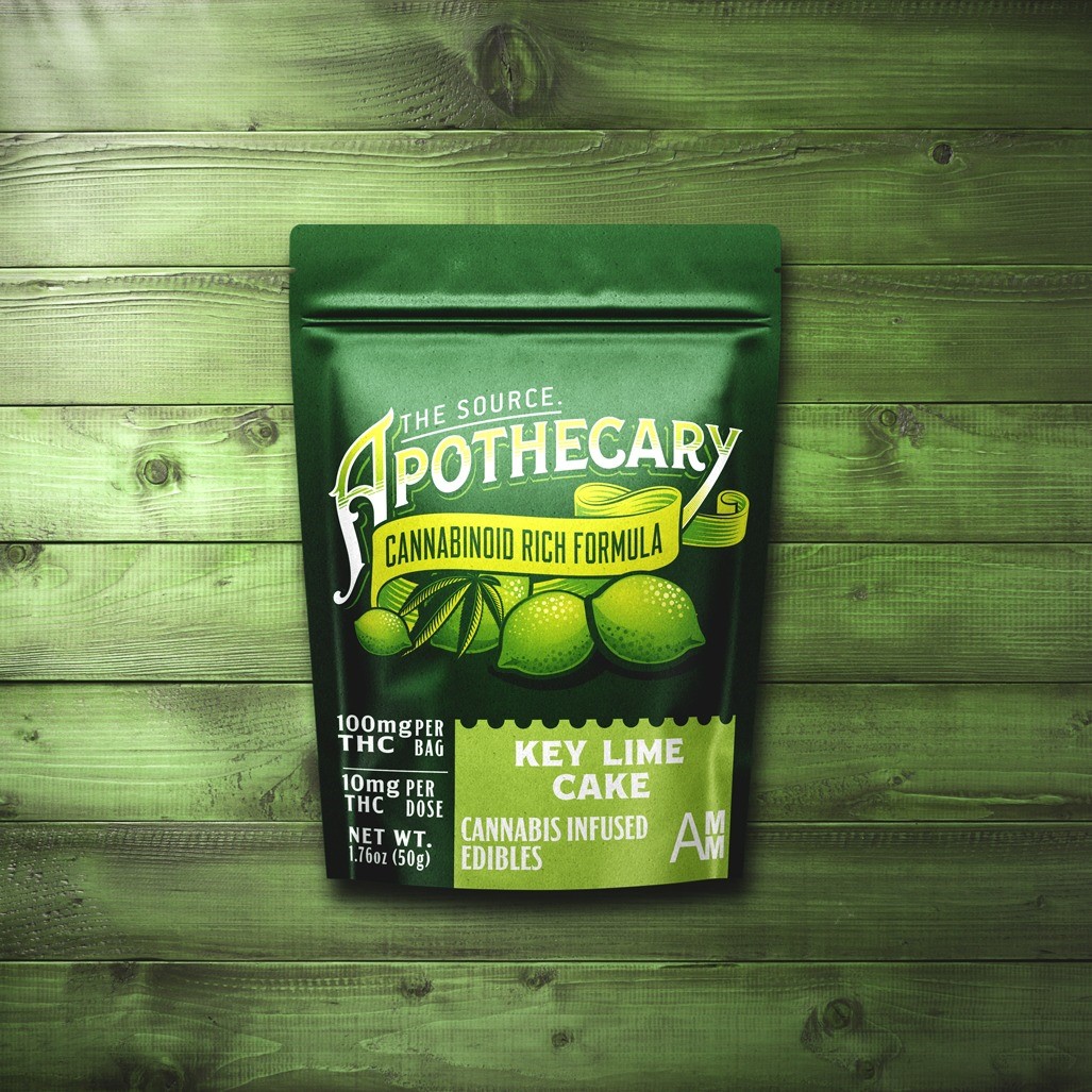 The Source Apothecary Cannabinoid Rich formula Key Lime Cake cannabis edibles infused with alternative cannabinoids, like CBD, CBN, and CBG plus THC. The kraft paper packaging is shown from a birds eye view and the background is multicolored wood.