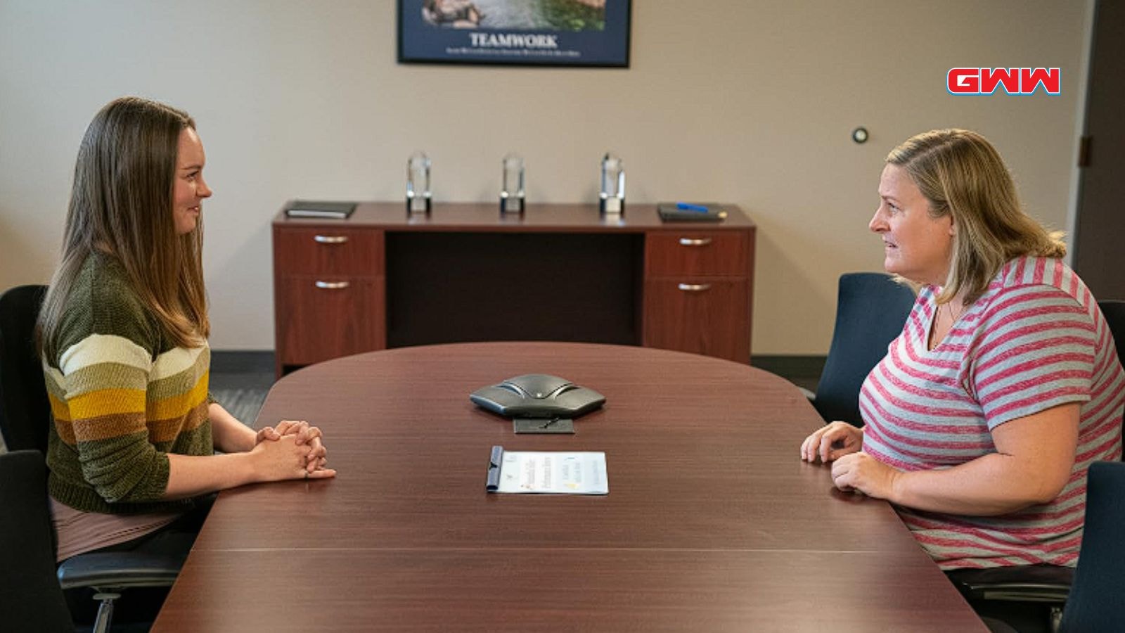 Bridget Everett in a serious conversation with Kailey Albus in an office setting