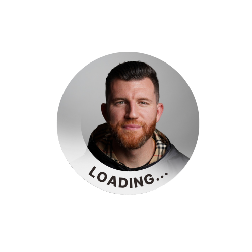 a profile photo that has been modified as part of the Notion LinkedIn campaign. It shows a professional headshot of someone with styled dark hair and a red beard, wearing what appears to be a plaid or Burberry-style scarf or collar. The image has been modified to include a "LOADING..." text overlay at the bottom, giving it the appearance of being in a loading or transitional state. The photo is circular, as is typical for social media profile pictures, with a light gray background.