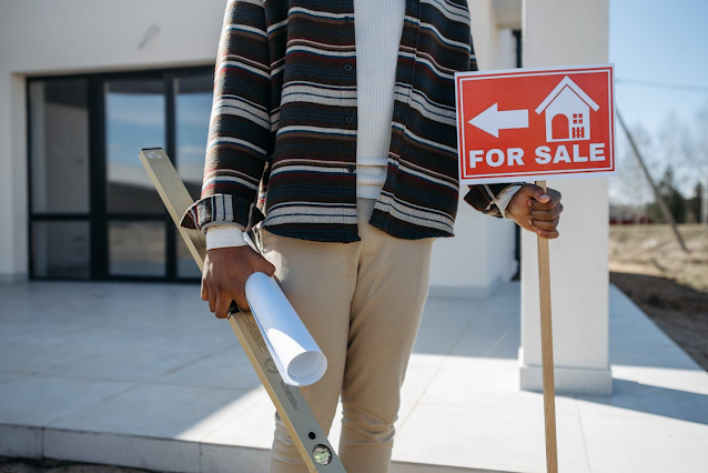man putting up for sale sign