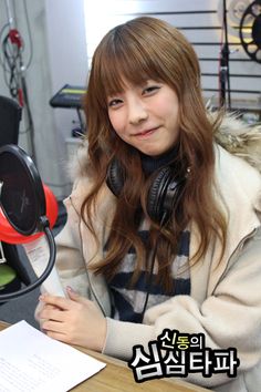 This may contain an image of singer juniel sitting at a desk with headphones on and papers in front of her