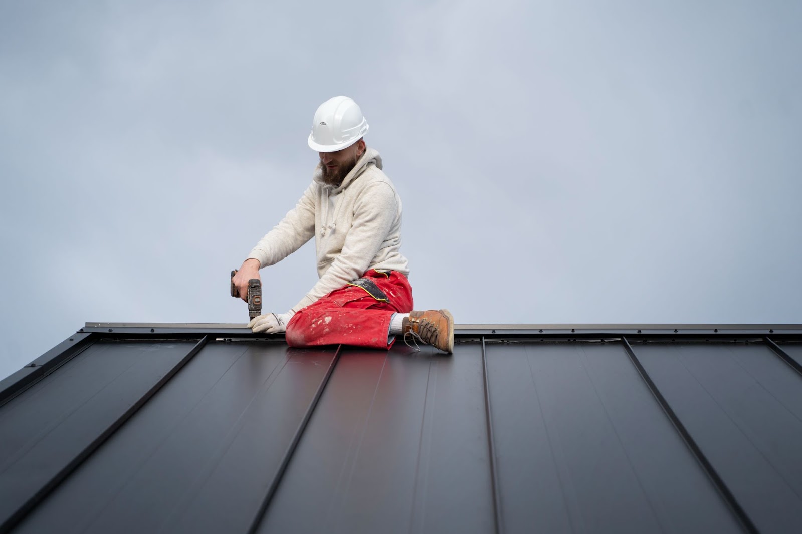 Roofer nailing a new metal roof