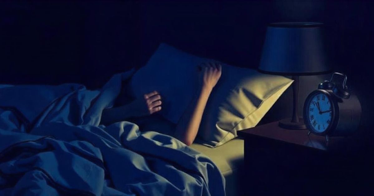 A person peacefully sleeping in bed beside a clock, symbolizing a time of increased REM sleep.