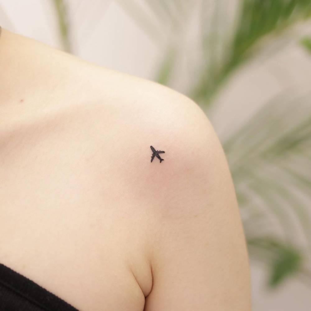 Minimalist airplane tattoo on the shoulder