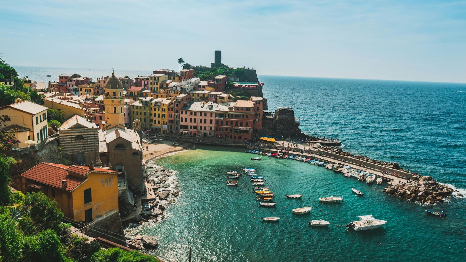Colorful seaside town on the Italian coast, with small boats in the harbor – representing the charm of Italy yacht charters in summer.