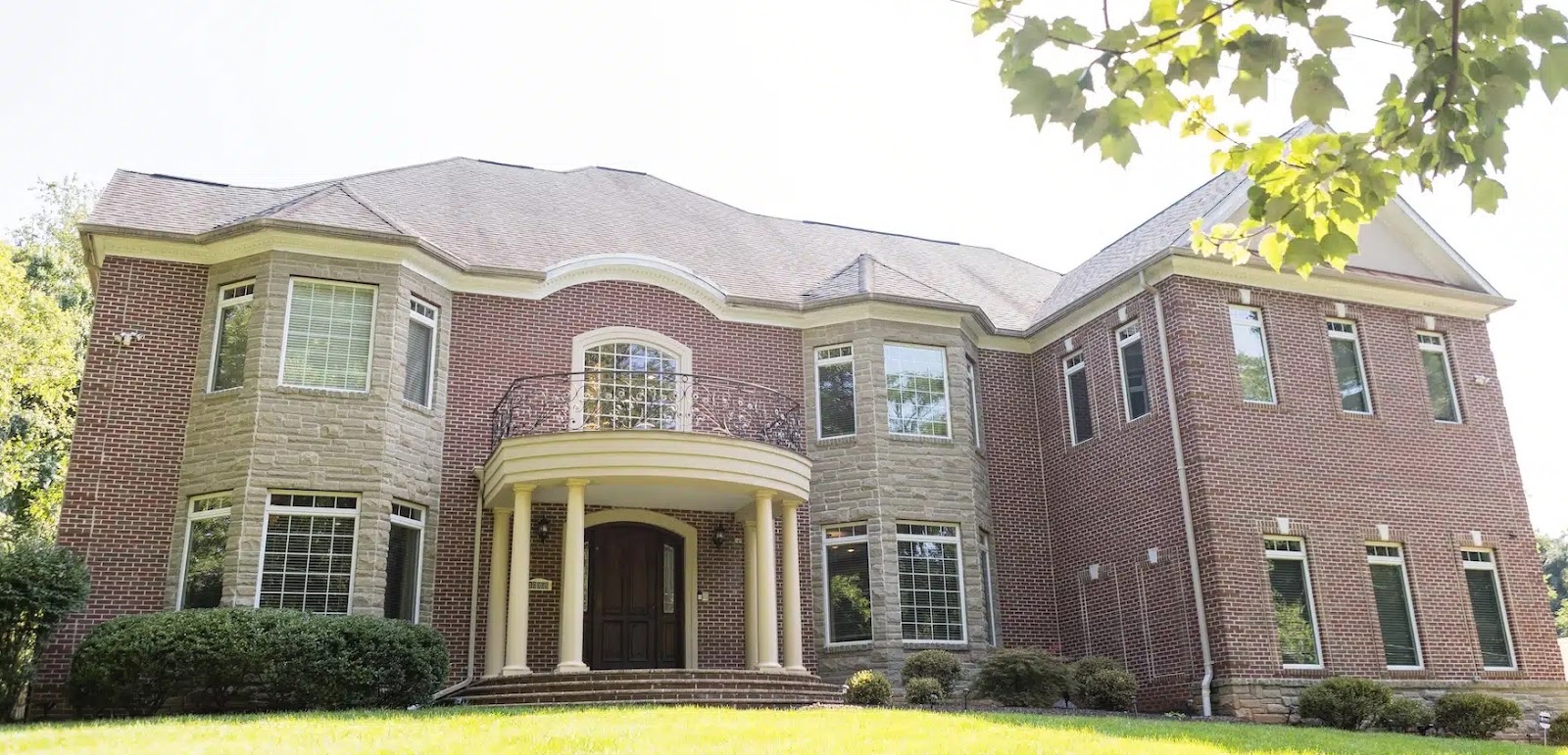 Exterior view of an AMFM facility in Virginia, featuring a stately brick building with large windows and a landscaped lawn.