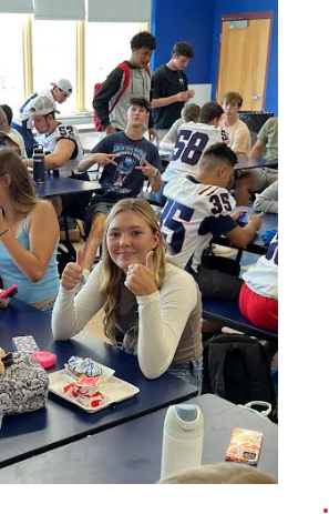 image of students in the cafeteria with one giving a thumbs up sign