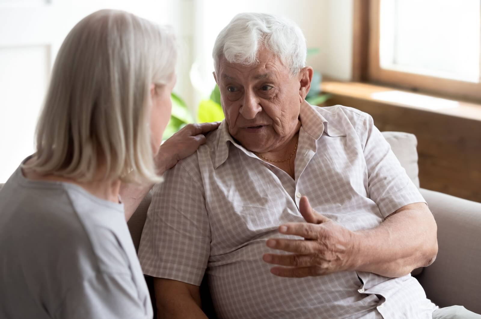 An adult child listening attentively to a parent with dementia talking.