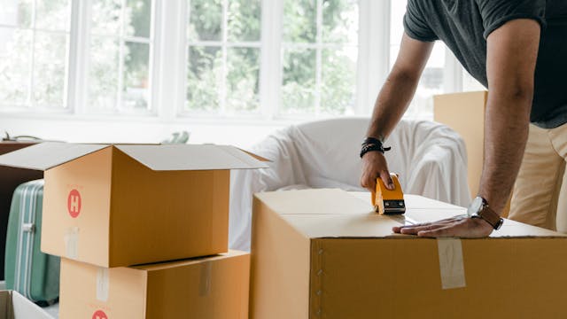 person tapping a box shut