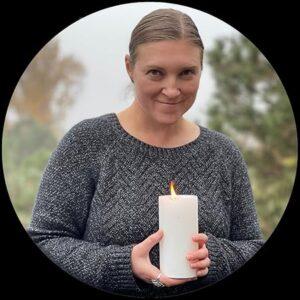 A person holding a candle

Description automatically generated