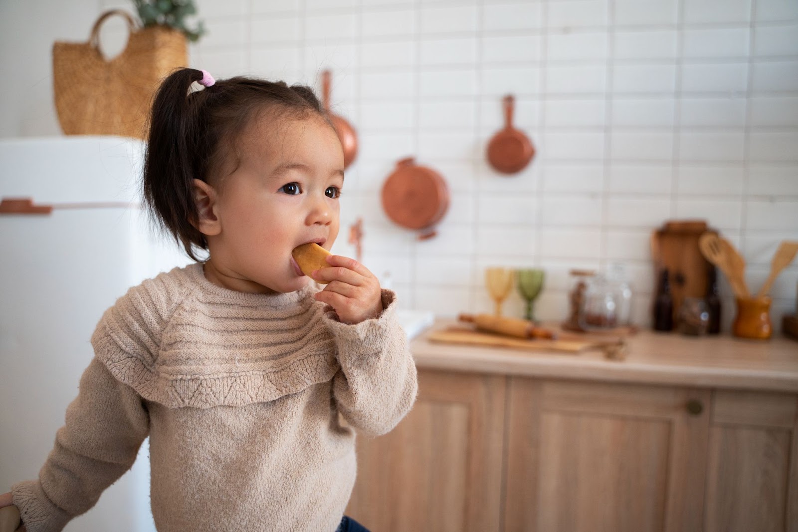 A young girl biting her snack