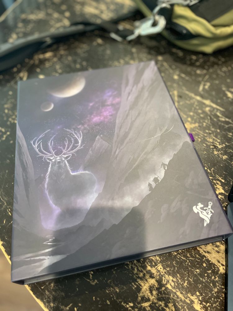 Picture of the Daggerheart box.  It's got a big weird ghost stag thing under two moons looking down at what might be a relatively tiny adventuring party in silhouette.  Big time van art vibe. 