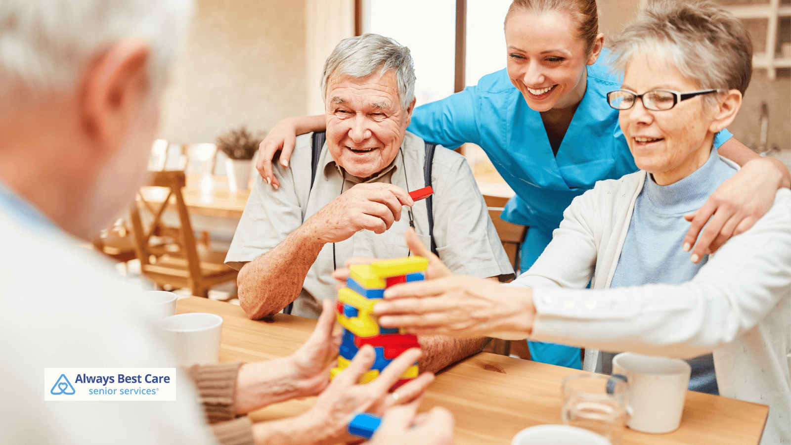 This image depicts several seniors and a caregiver playing Jenga