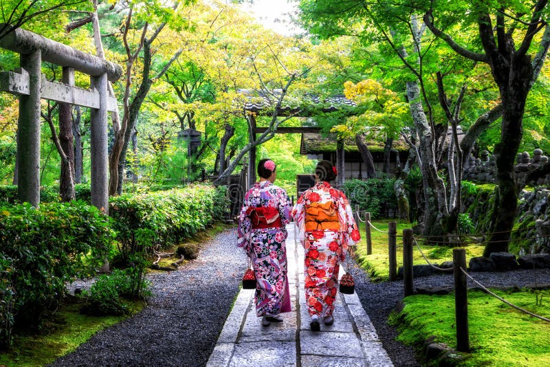 Un viajero con un kimono tradicional camina por un jardín japonés en Kioto, demostrando la elección perfecta de la ubicación para la fotografía cultural.