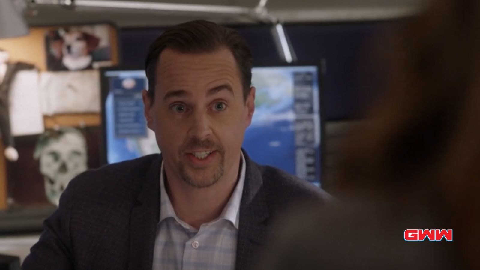 SSA Timothy McGee with short brown hair, talking animatedly in a modern office.