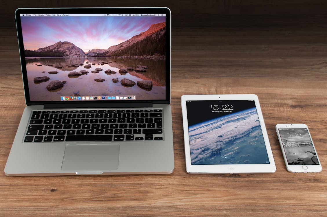 Flat lay of a MacBook, iPhone, and iPad on a table representing the tools Instagram creators use to manage content and analytics