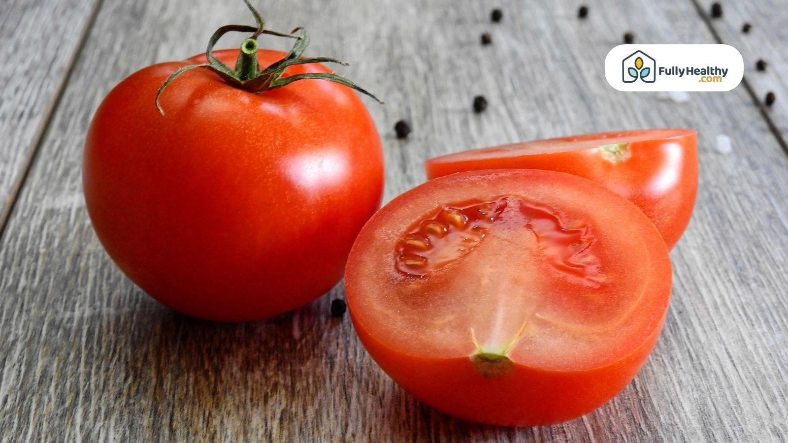 Tomato plants growing in rows with ripe red fruits hanging