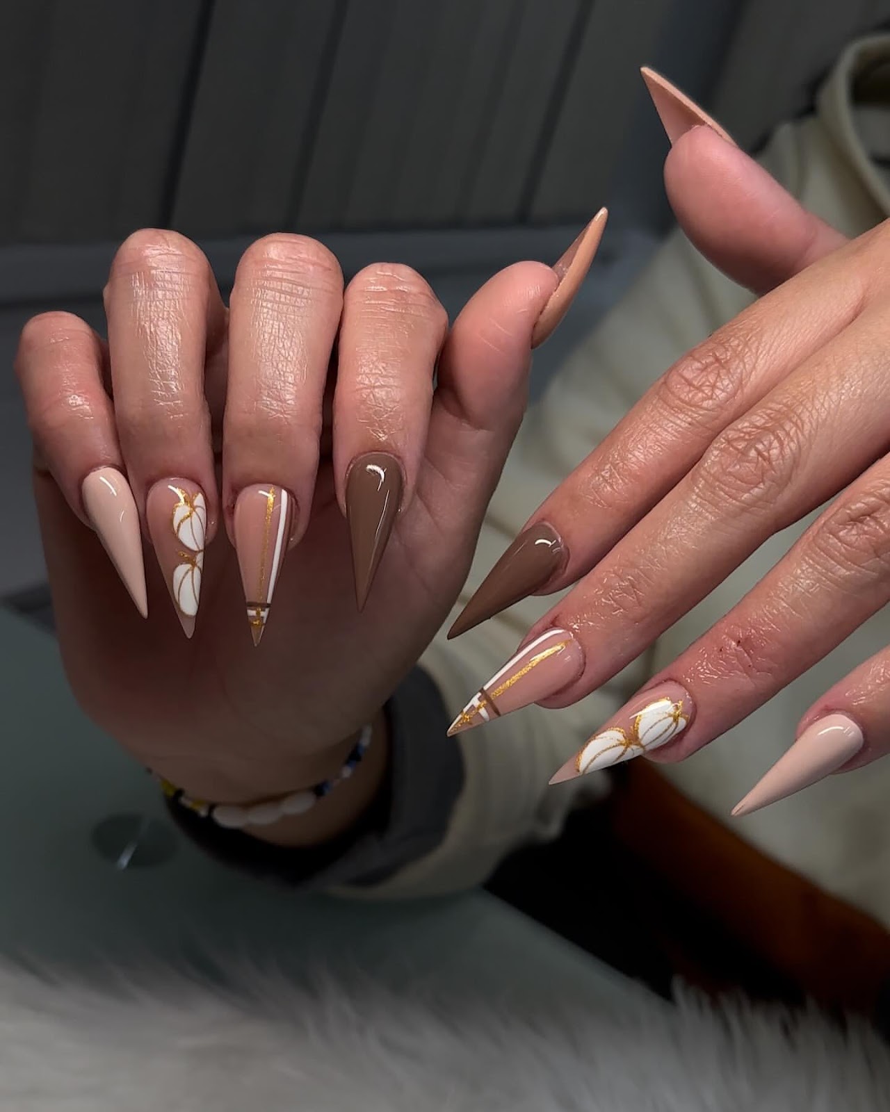 Close-up of hands with fall nail design having Stiletto Nails