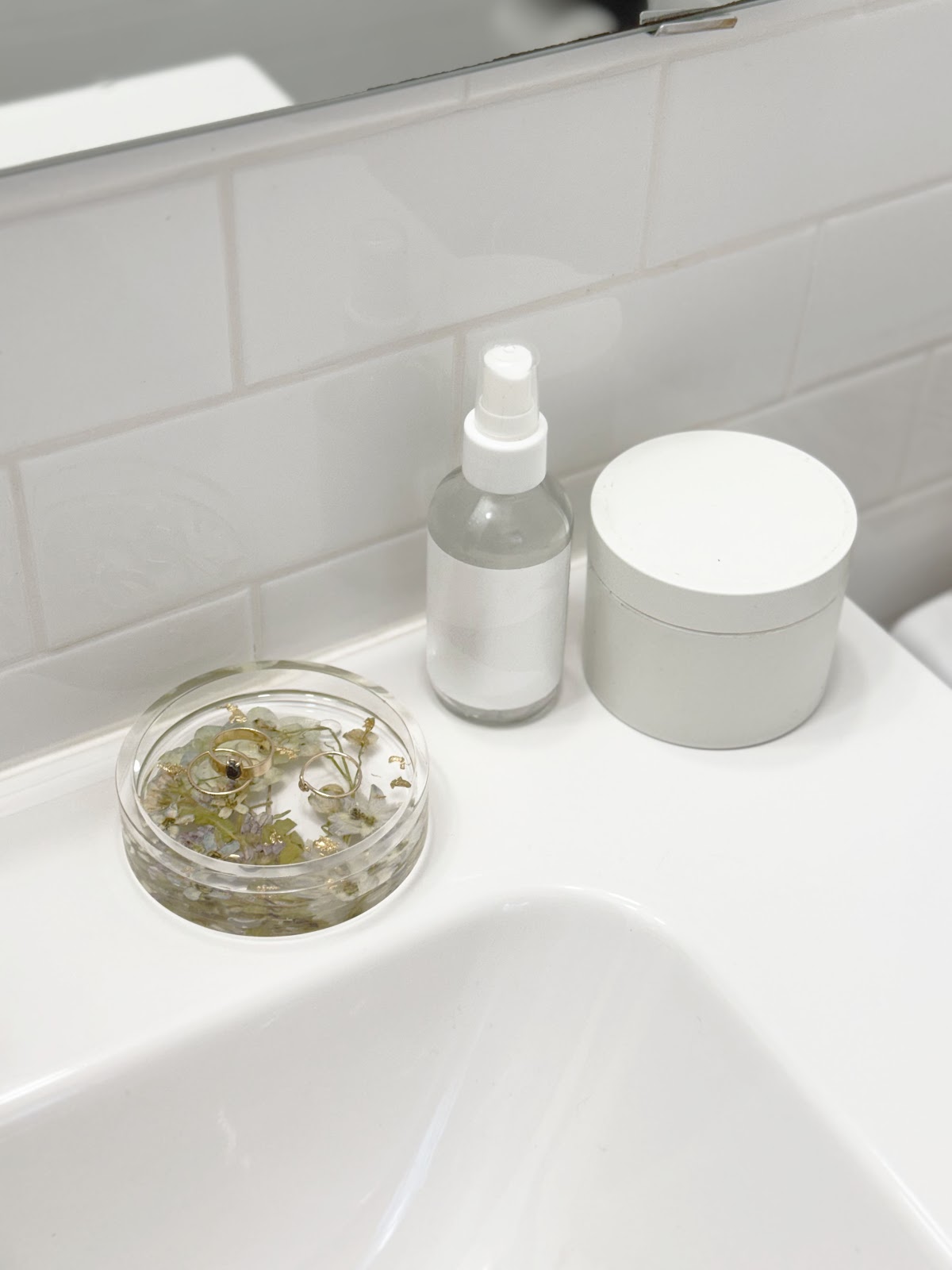 a ring dish and other toiletry items on a bathroom sink