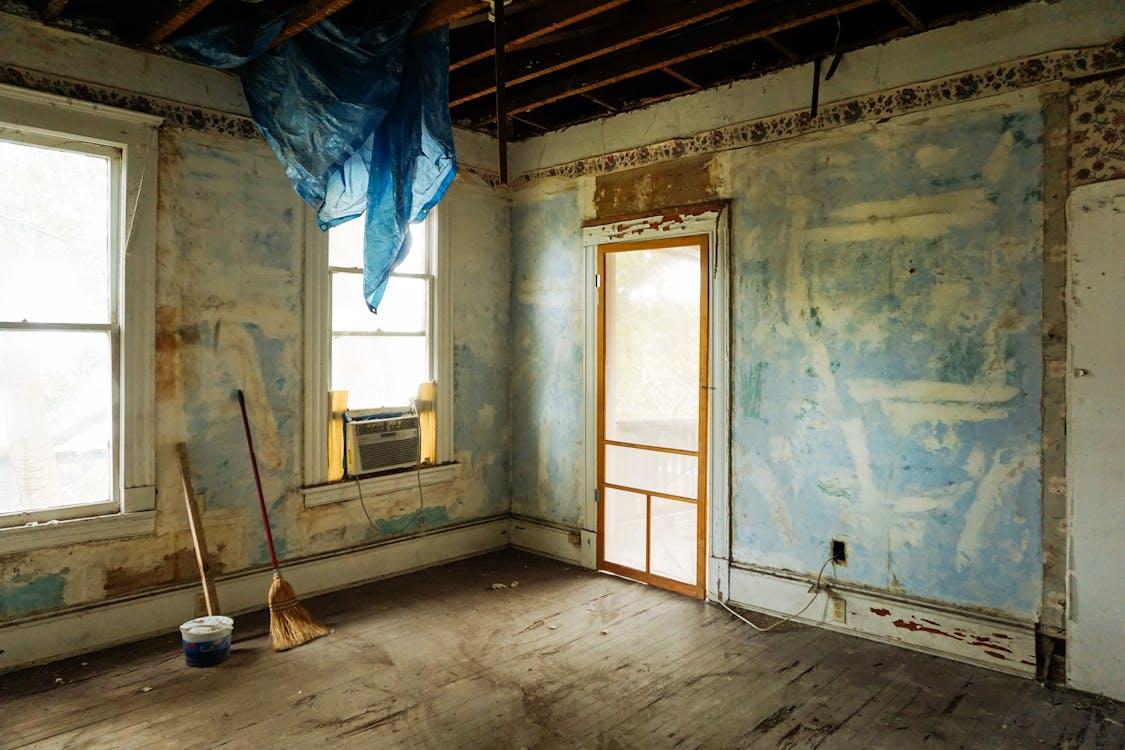 Free An empty room in an abandoned house with peeling walls and construction tools. Stock Photo