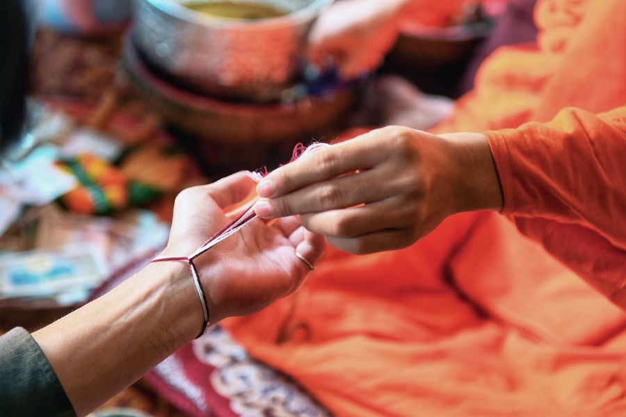 In addition to the water-splashing tradition, Laotians also practice the wrist-tying ceremony to offer blessings. 