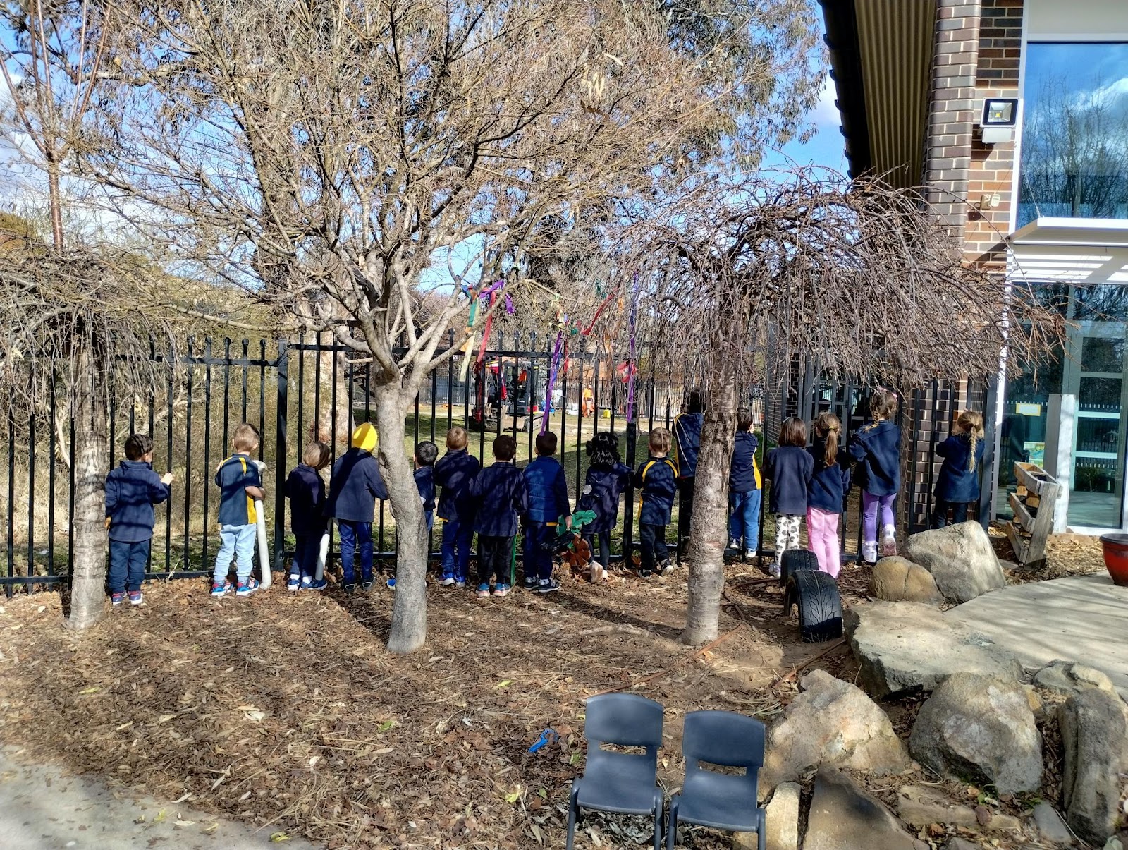 A group of children standing in a line behind a fence

AI-generated content may be incorrect.