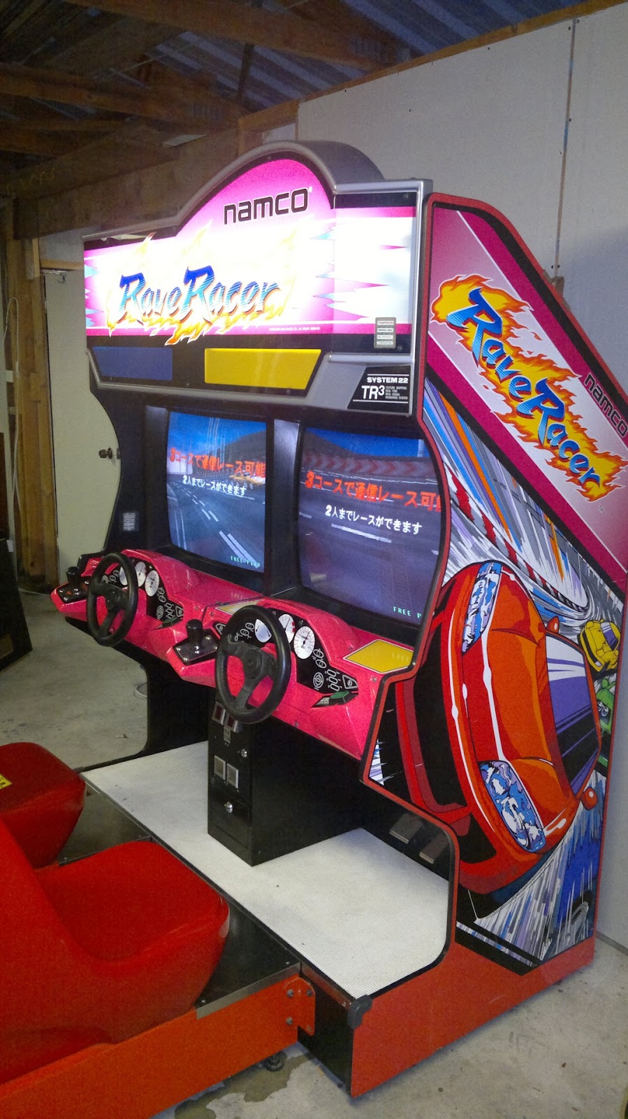 Japanese Rave Racer cabinet with red dashboard and 2 seats.