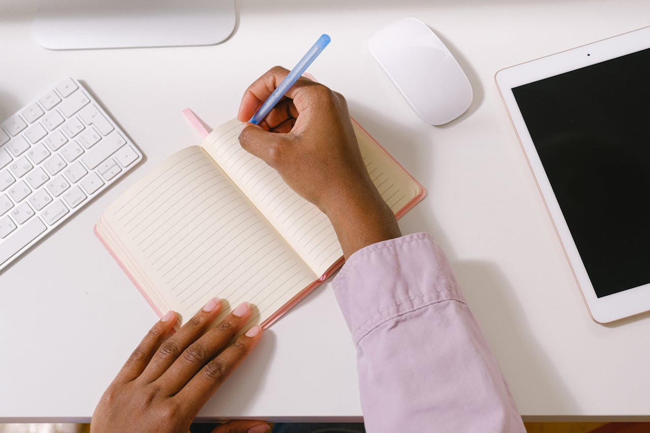 A woman's hand gracefully writing in a notebook