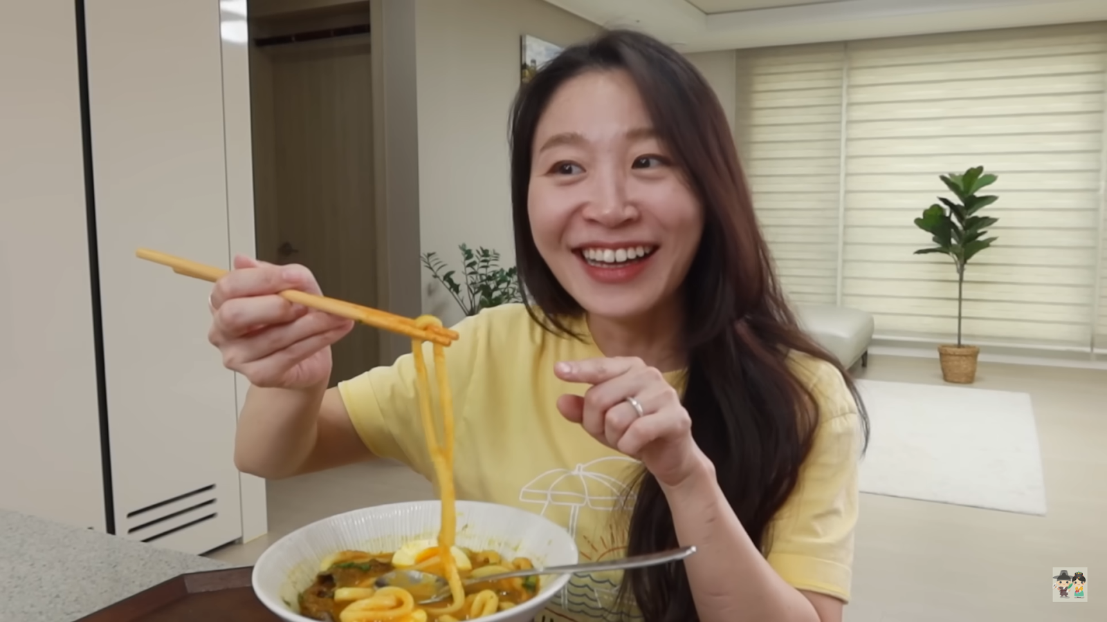 Claire smiling with a plate of their homemade curry udon