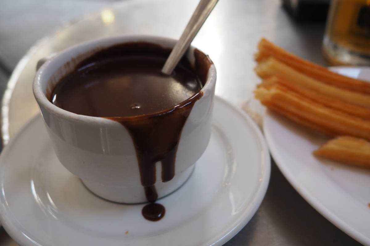 Liquid chocolate in the cup and stick are kept in plate