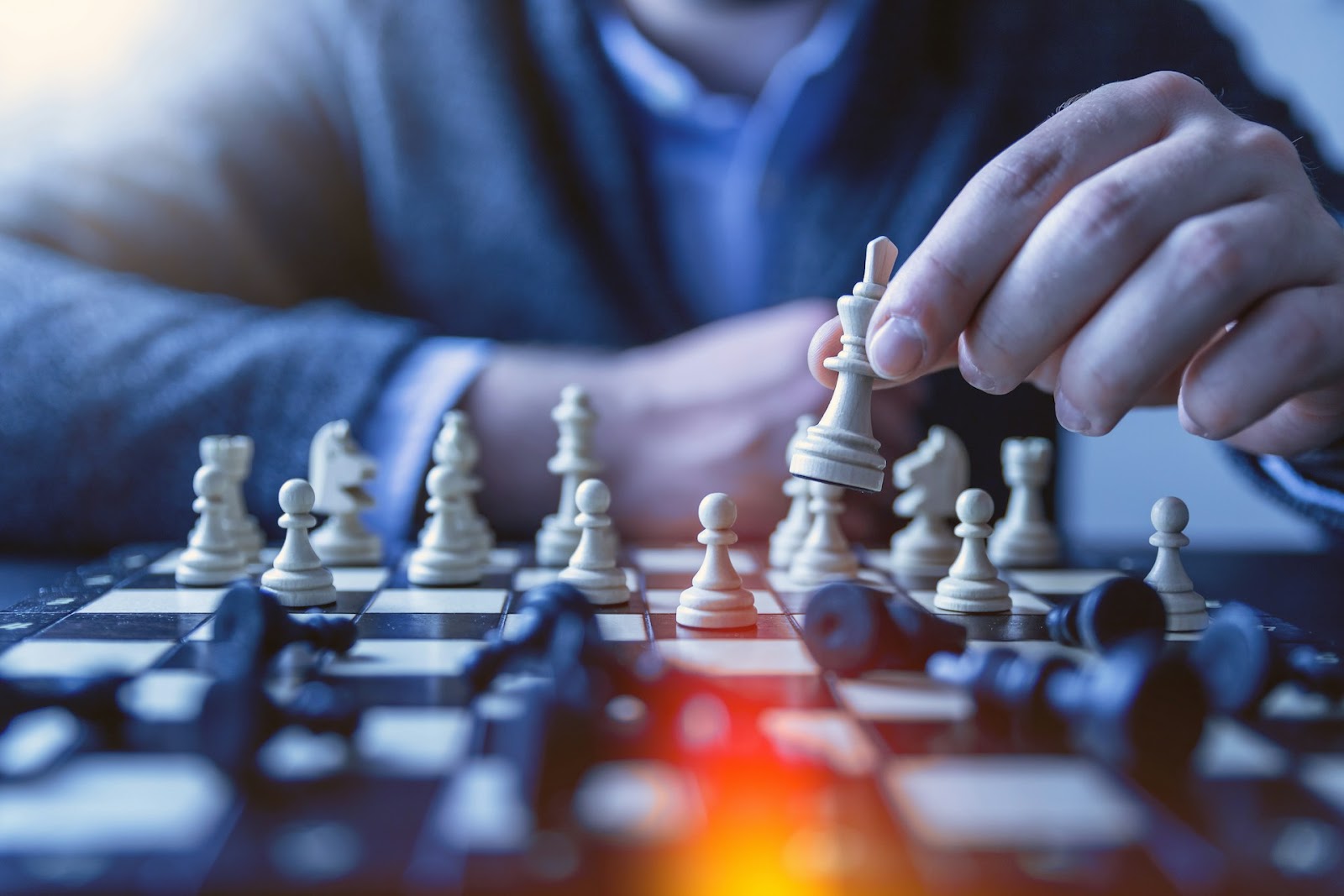 Person making a strategic move in a chess game, symbolizing the need to value small business decisions for long-term success.