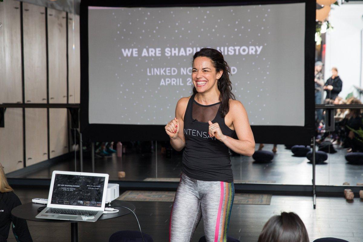 A photo of historian Dr. Natalia Petrzela wearing a sports attire as she does a presentation in a gym studio. She specializes in American sport culture.