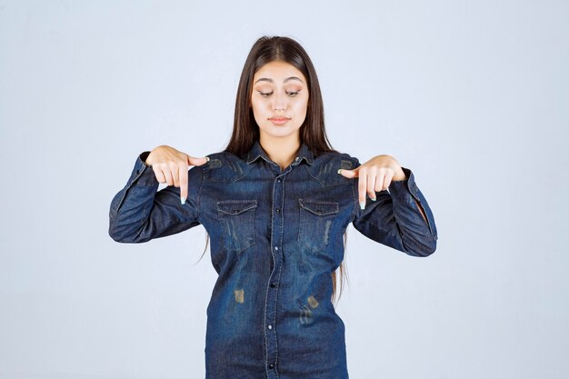 A girl is pointing down towards blog post ideas for writers