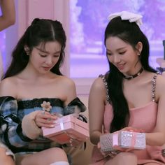 This contains an image of Irene and Karina sitting next to each other holding gifts