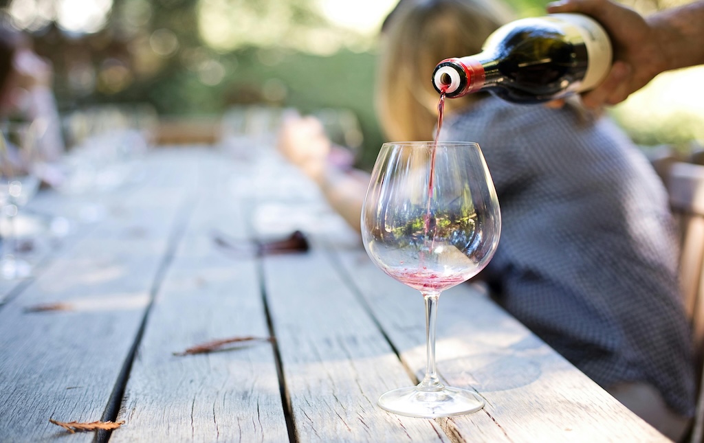 wine being poured into a glass outside