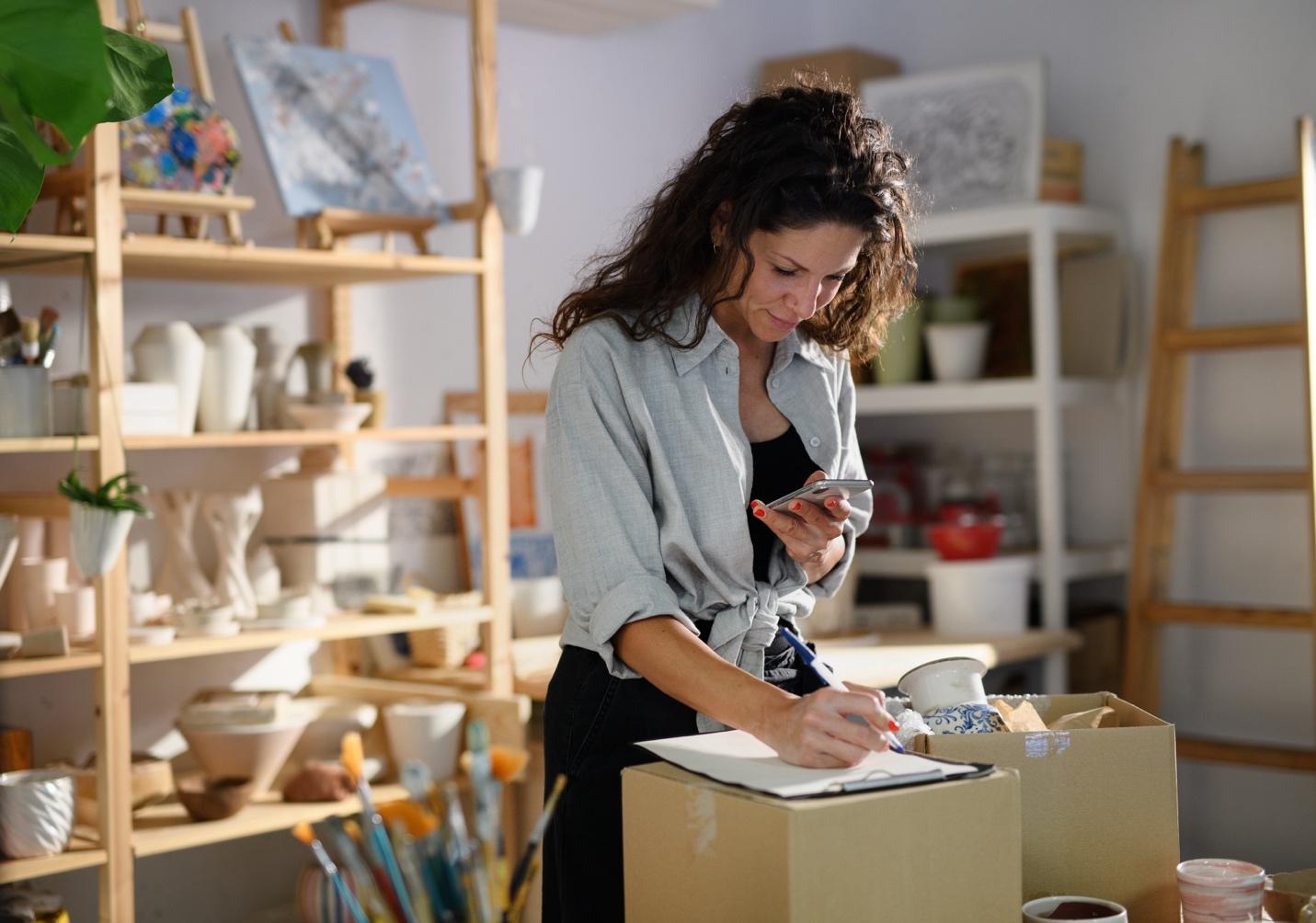 Woman in art studio using phone