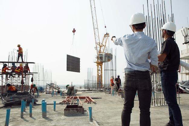 Photo two engineers work on the construction site