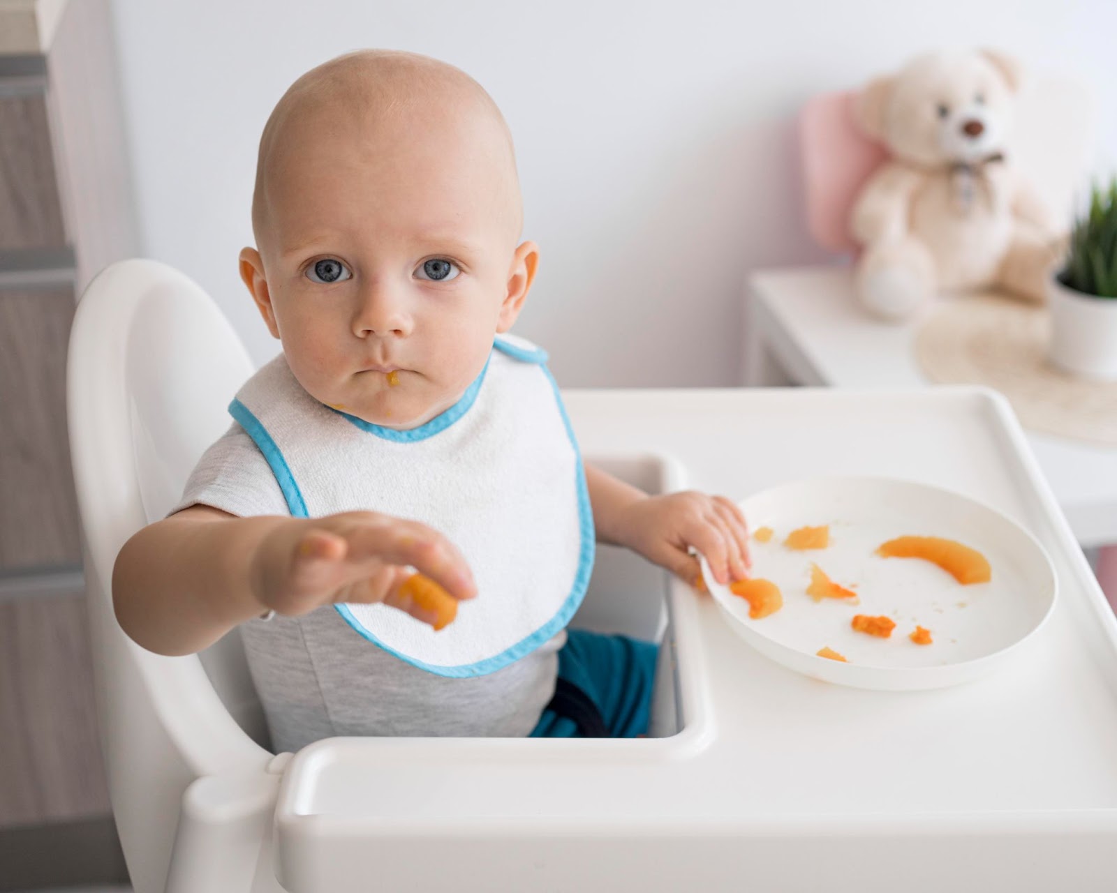 A little boy eating on his high chair