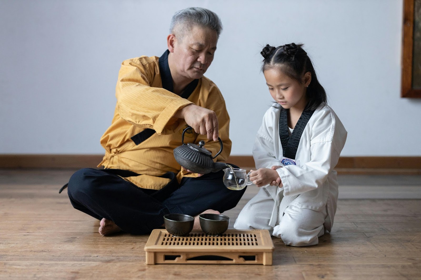 A martial arts instructor sharing a cup of tea with a young student