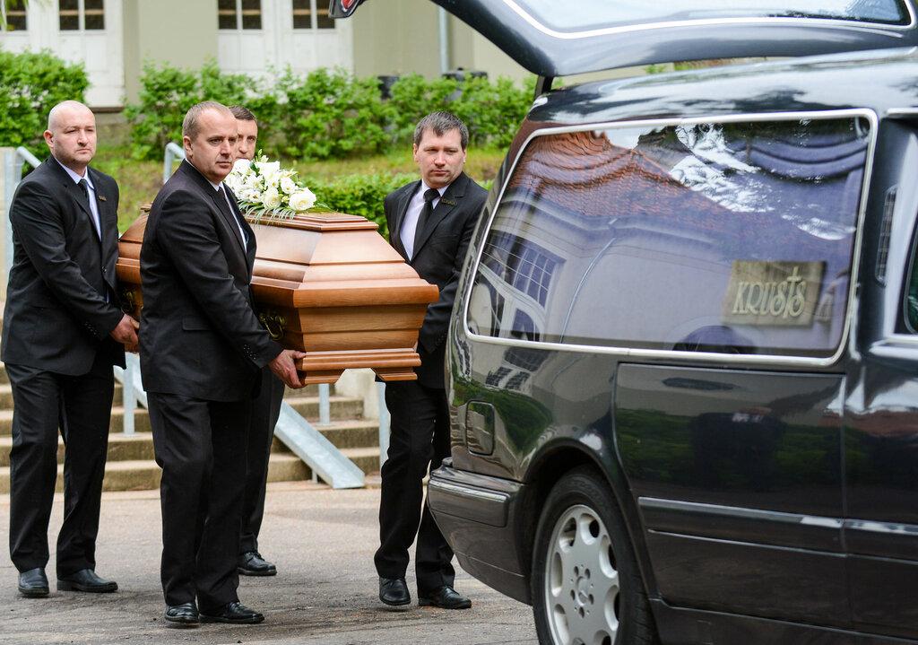 A group of men carrying a coffin
AI-generated content may be incorrect.