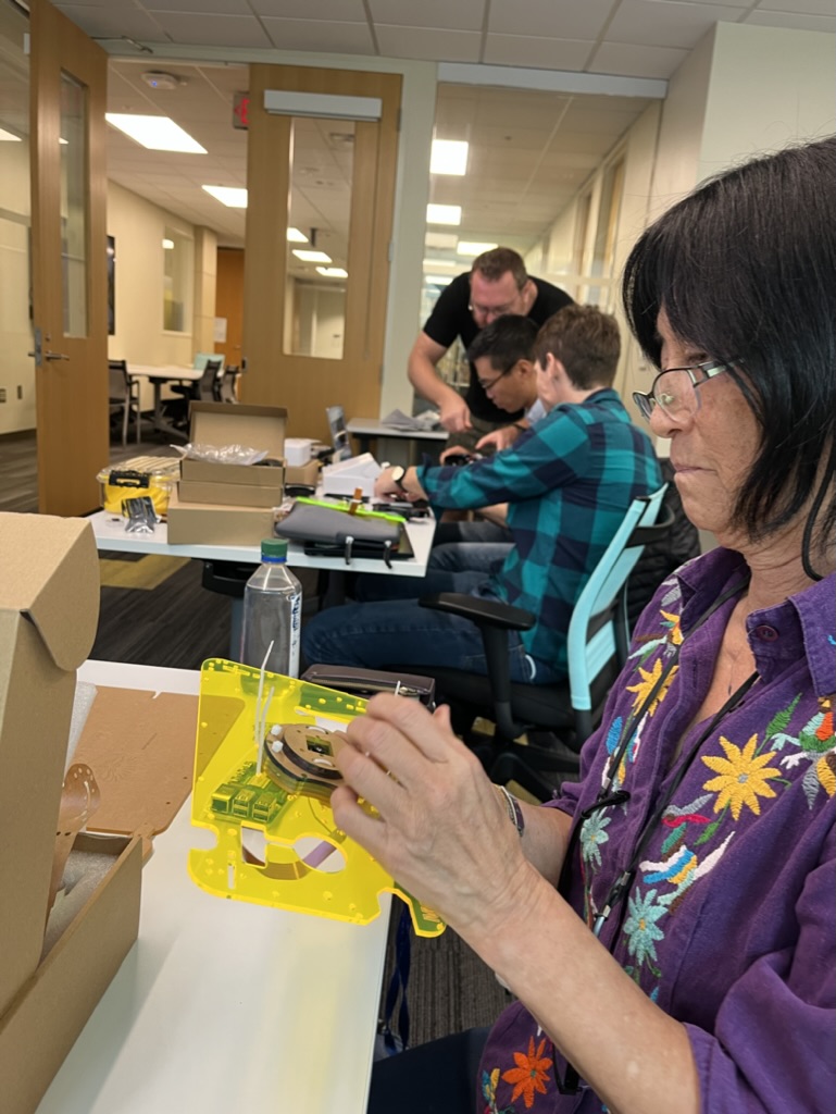 Photo of a workshop attendee attaching the camera glare blocker to the main board of the Mothbox