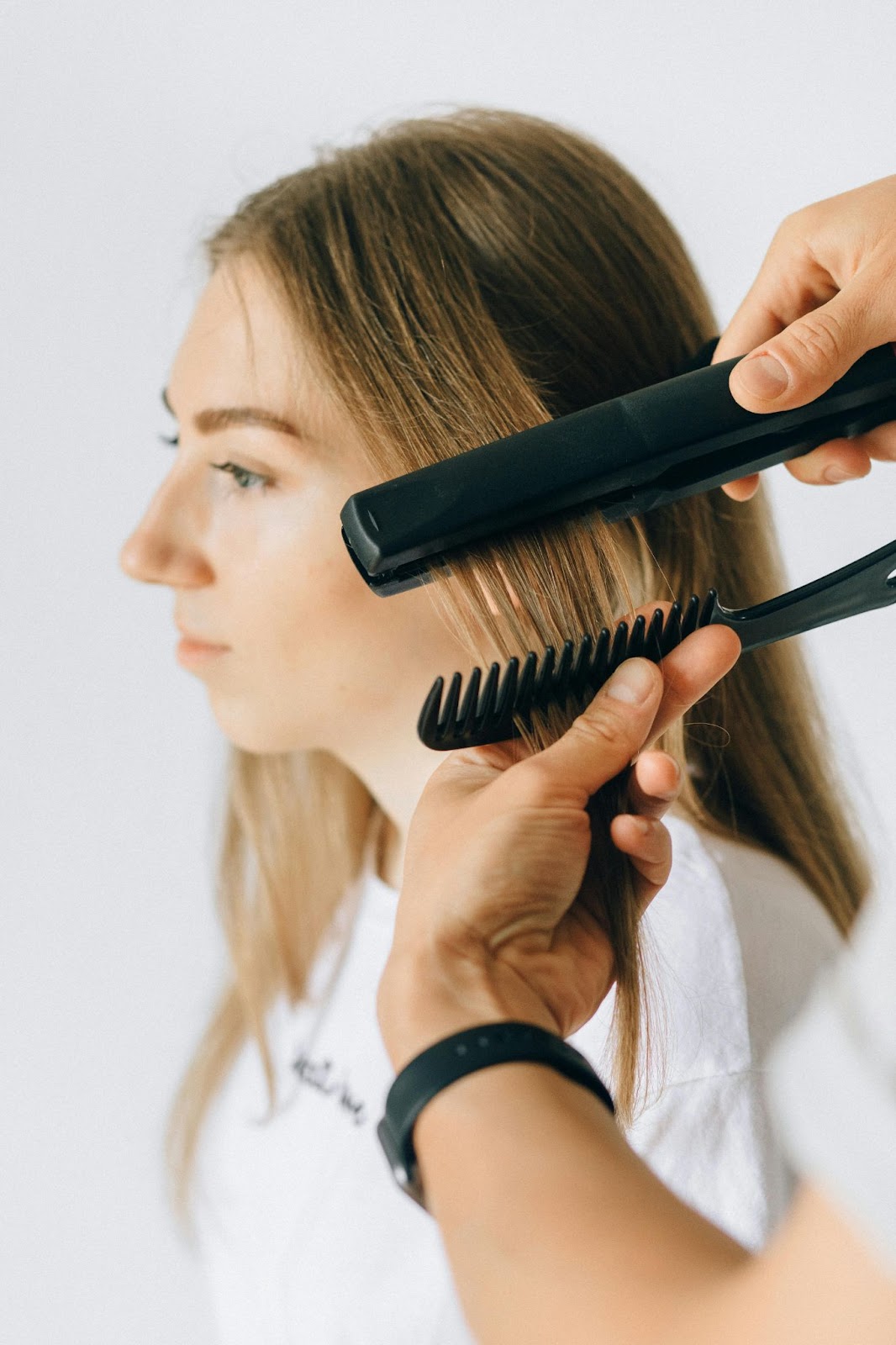A Stylist Straightening a lady's Hair