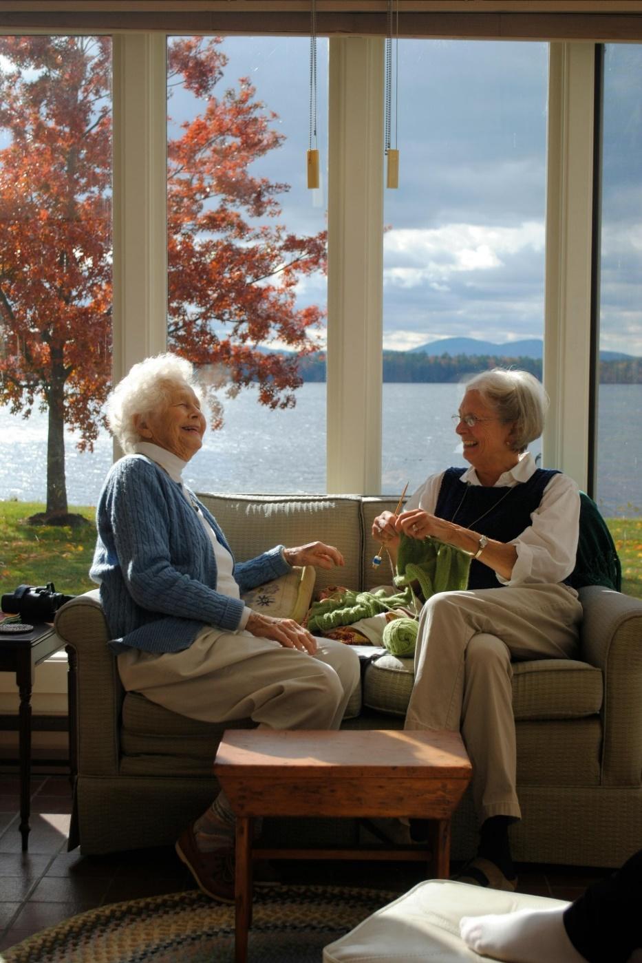 A couple of elderly women sitting on a couch

Description automatically generated