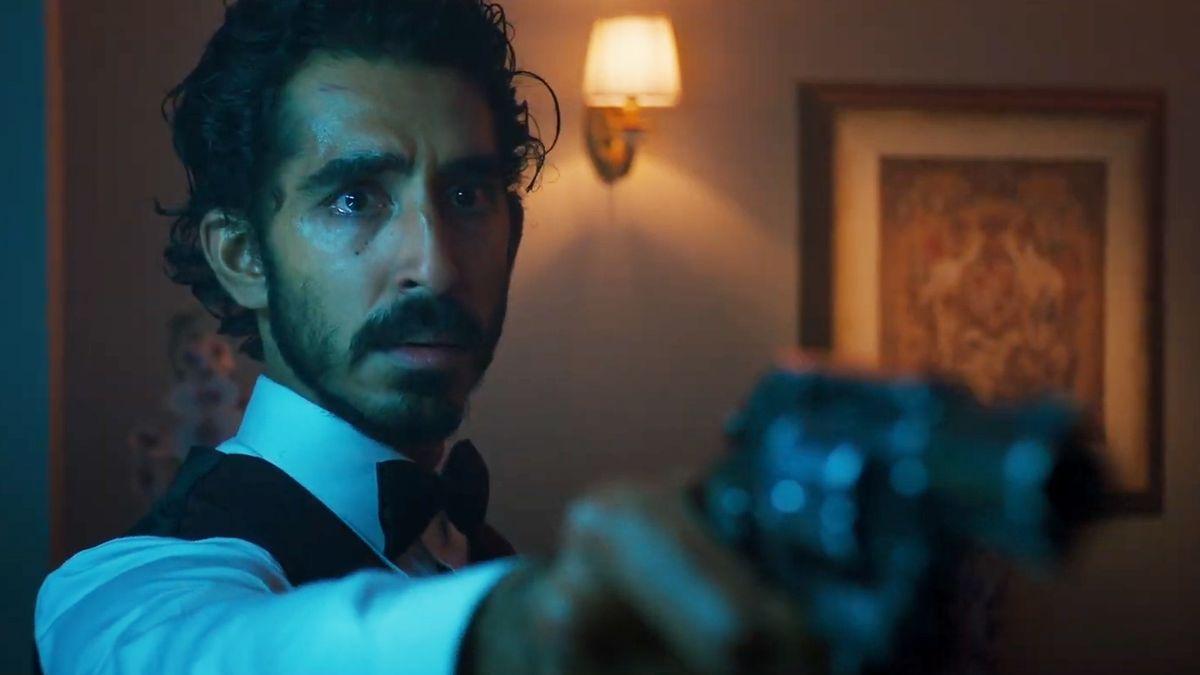 Dev Patel protagonizando su primera película, Monkey Man, mientras sostiene un revolver con la mirada consternada.