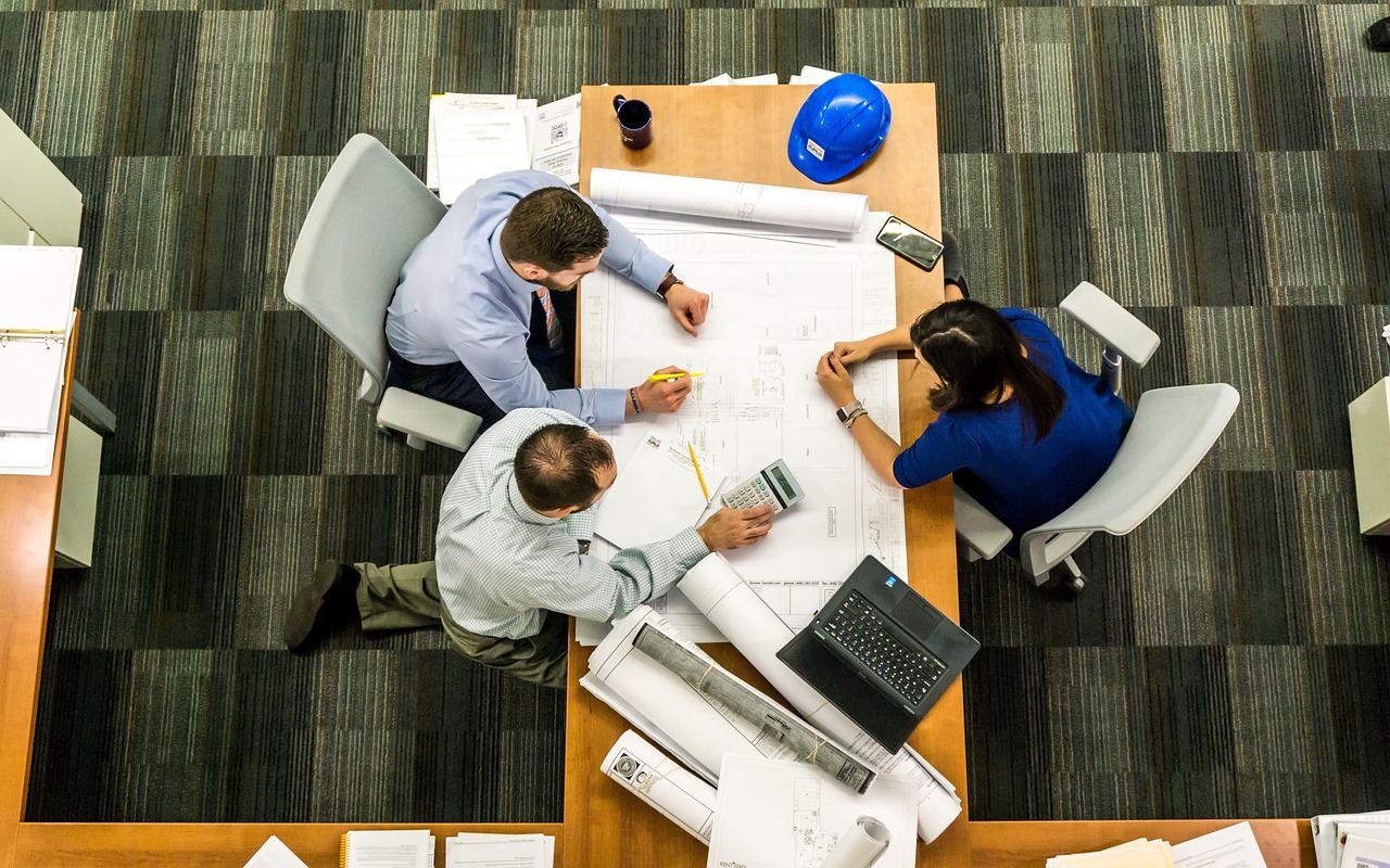 Group of people working over a desk covered with papers. How to lead boldly. Fix and Form Strategic Branding Agency, Denver, Colorado