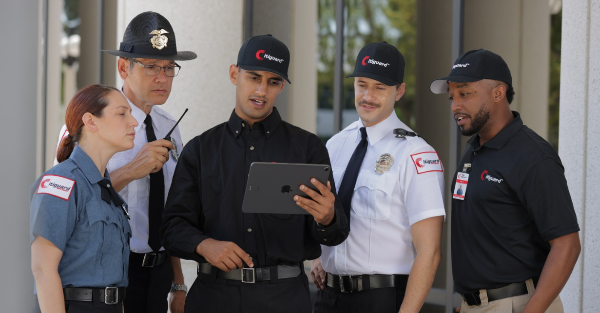 (Citiguard team members review surveillance or patrol data on a tablet during a strategic security briefing—highlighting professionalism, teamwork, and modern technology in private security services.)