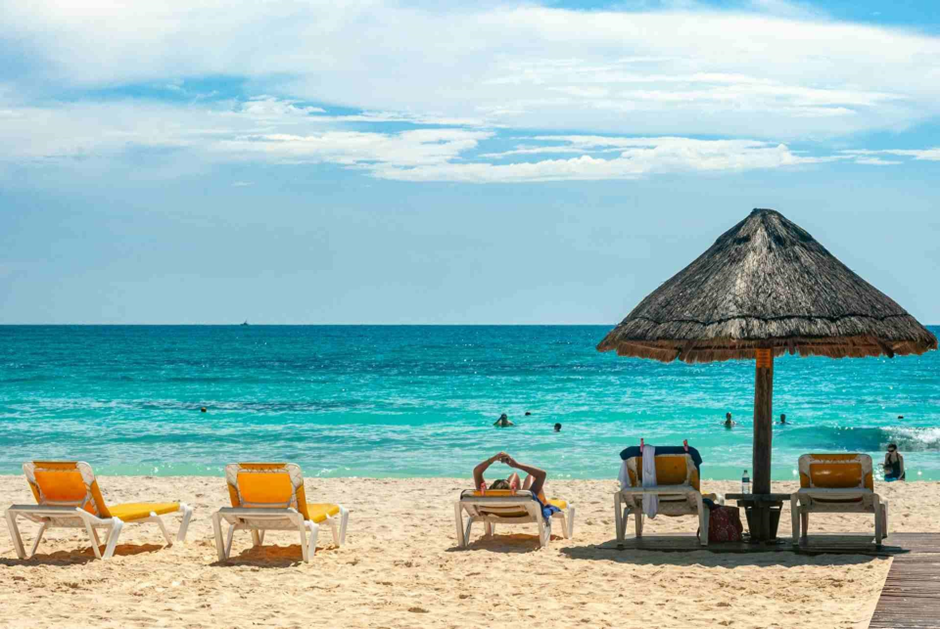 Delle sdraio e un ombrello su una spiaggia in Messico.