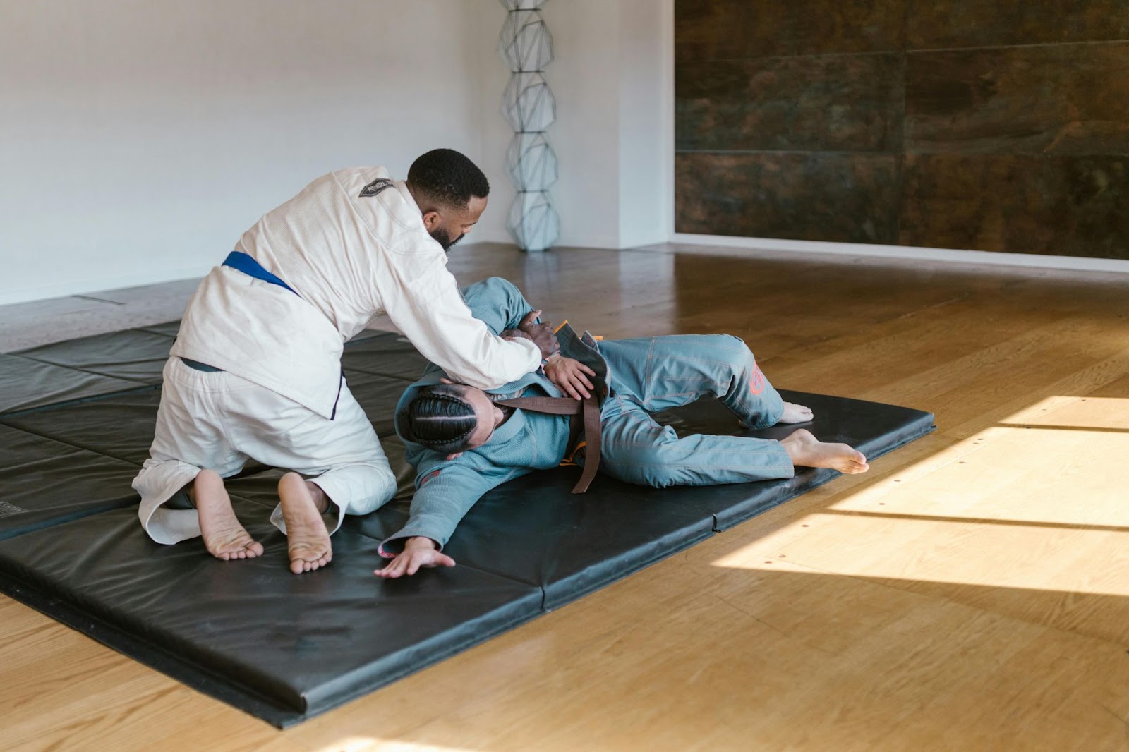 Two martial arts students practicing evasion techniques on the ground