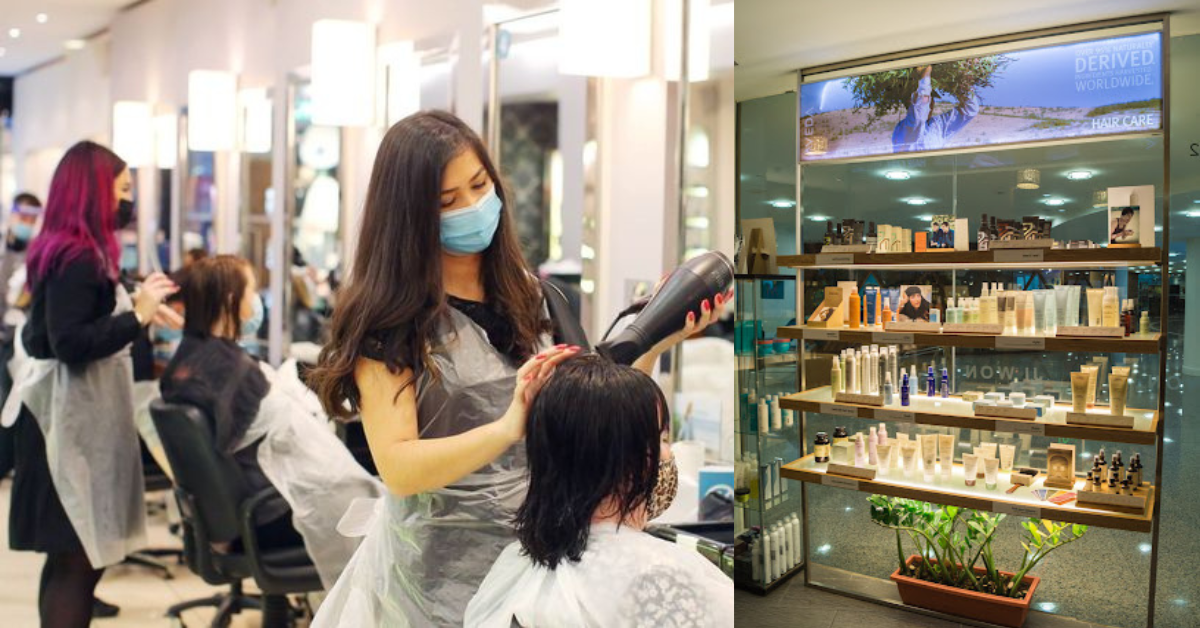 Left side: A salon scene where a hairstylist, wearing a face mask and protective apron, is blow-drying the wet hair of a seated client, who is also wearing a mask. There is another stylist working with a client in the background, with salon mirrors and lighting fixtures creating a professional environment.
Right side: A display of various hair care products arranged neatly on wooden shelves in a shop or salon. The products include creams, shampoos, and other hair care items, with a backlit sign promoting natural, derived hair care solutions above the shelves.